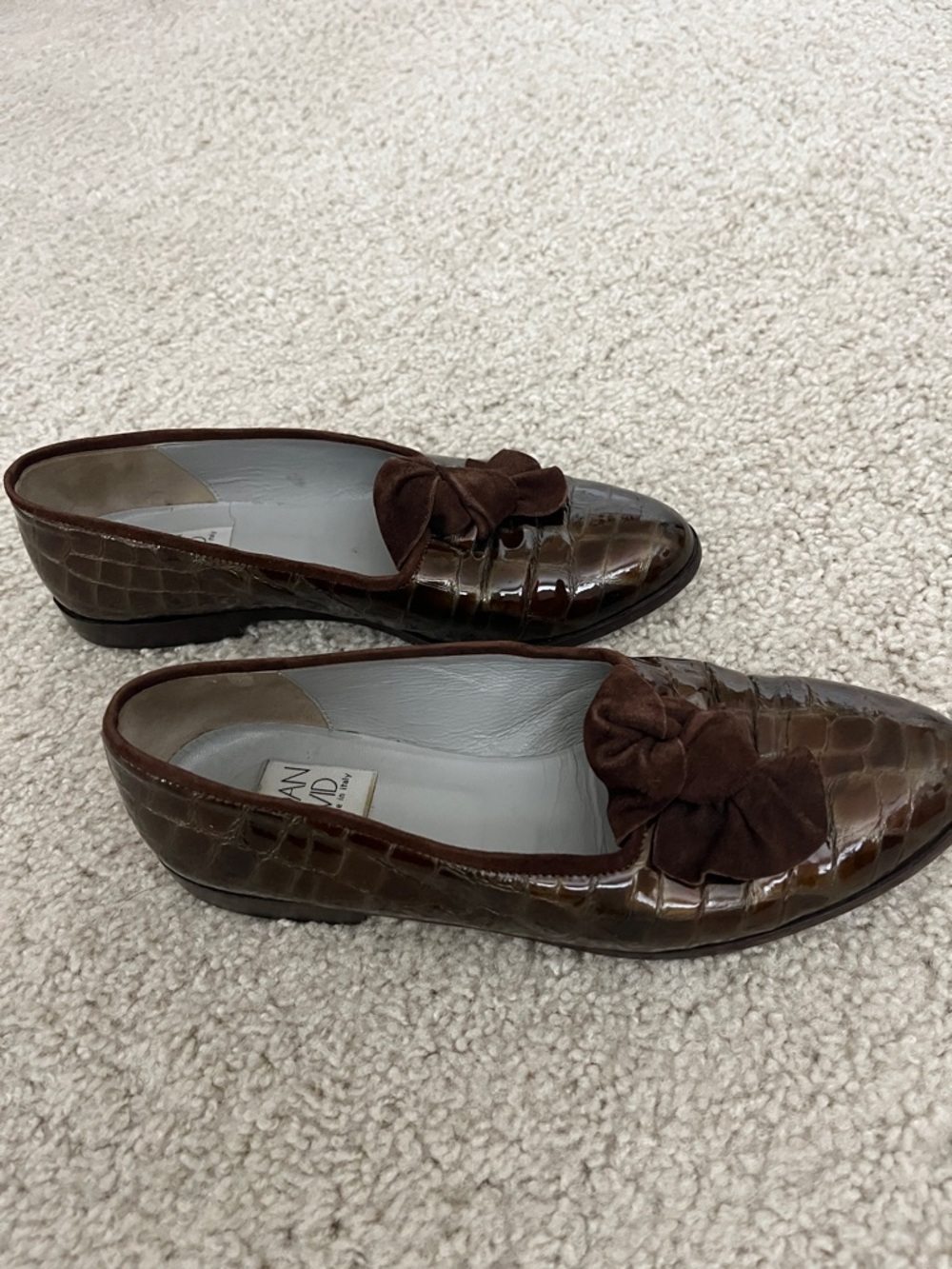These brown patent crocodile pattern leather slip ons are handmade in Italy.